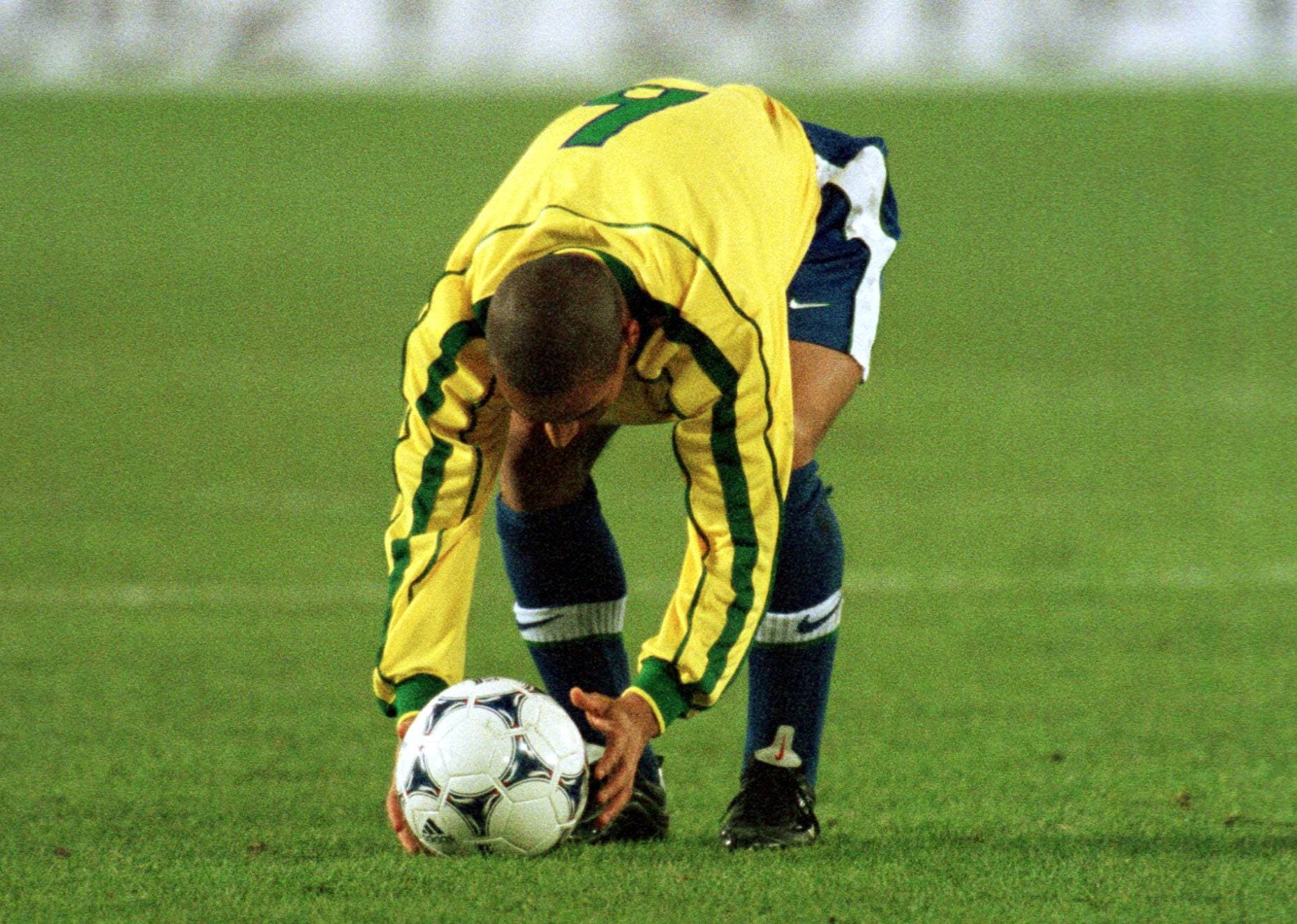 Roberto Carlos, number 6 for Brazil, bends over to place the ball for a free kick.