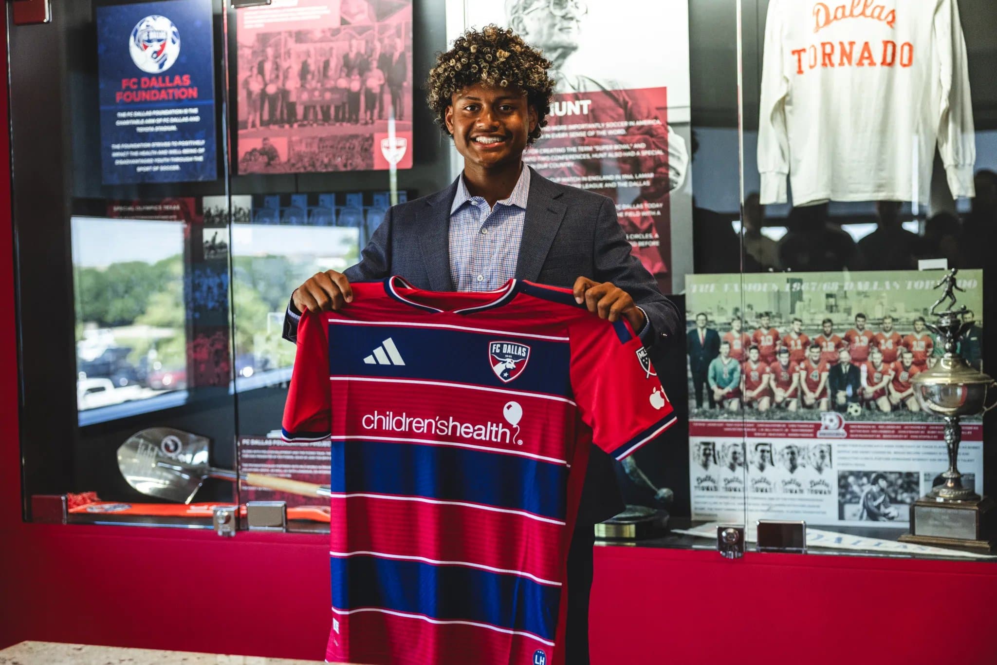 Benji Flowers holding up an FC Dallas shirt after signing.